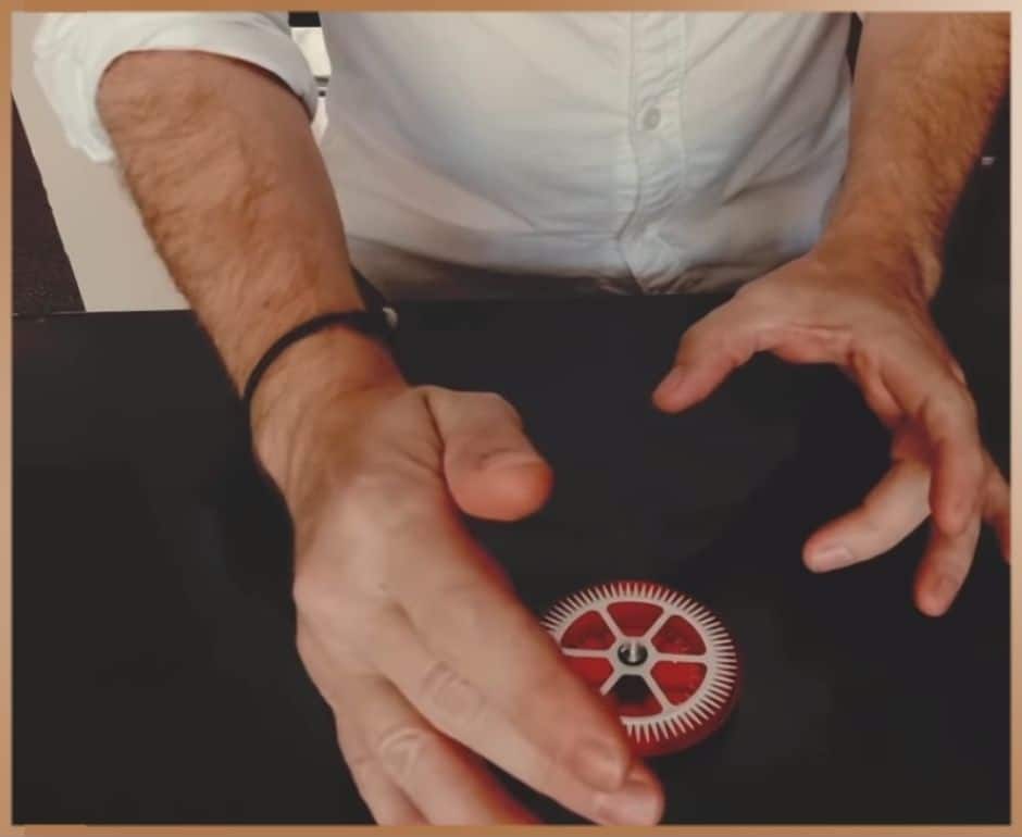 Man practices telekinesis by rotating a red Egely Wheel Vitality Indicator