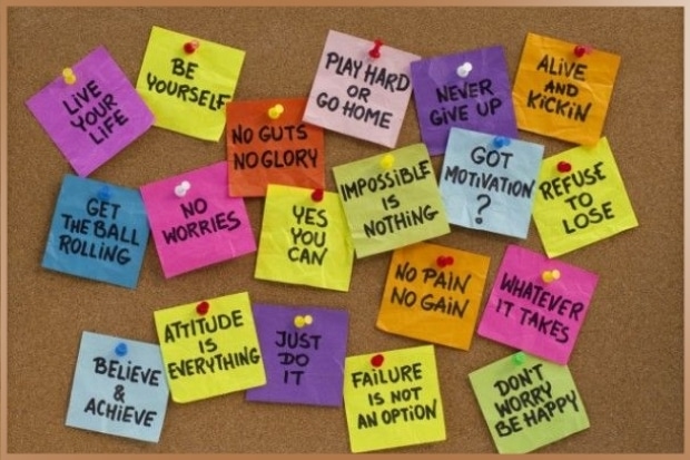 Positive thoughts written on post its pinned to a board as mantras for motivation