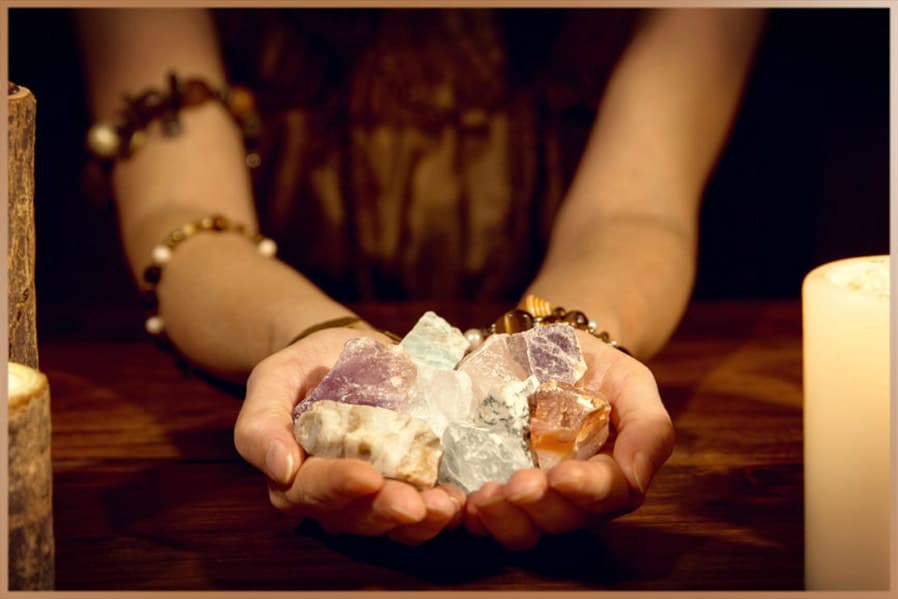 Different crystals in the hands of a spiritual healer woman