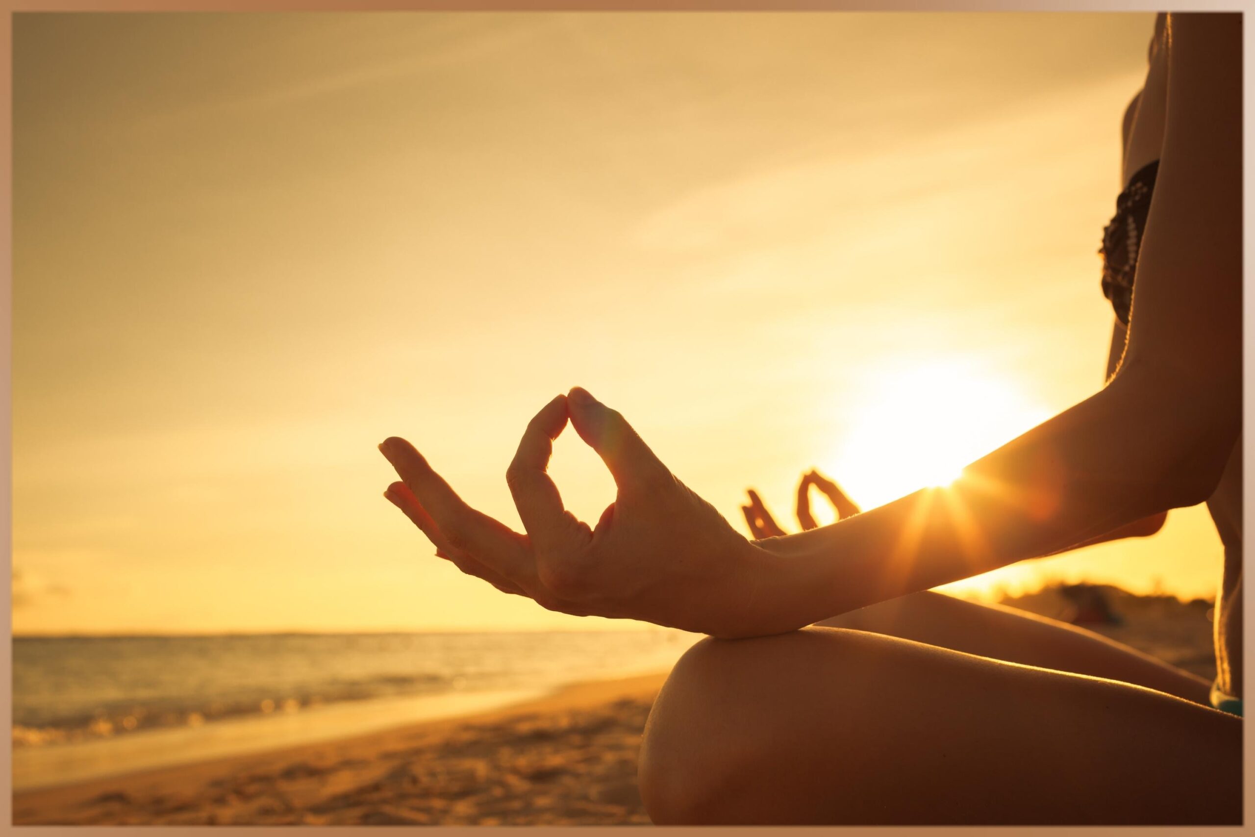 Woman meditates on the beach for inner peace while sun is shining
