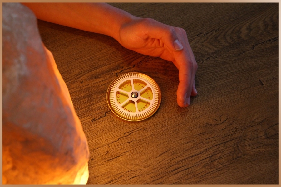 Hand spinning the Egely Wheel Vitality Indicator next to a salt lamp