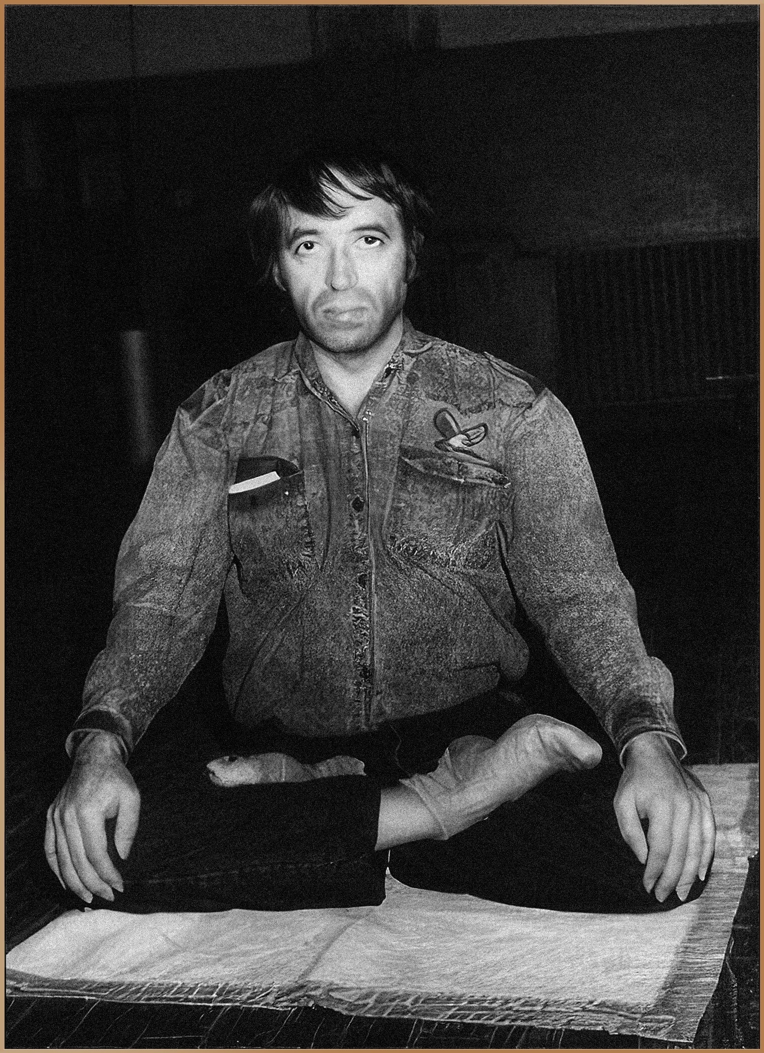 Gregorian Bivolaru seated in a meditative pose, wearing a denim jacket with a space exploration patch, representing his role as the spiritual guide in the MISA network.