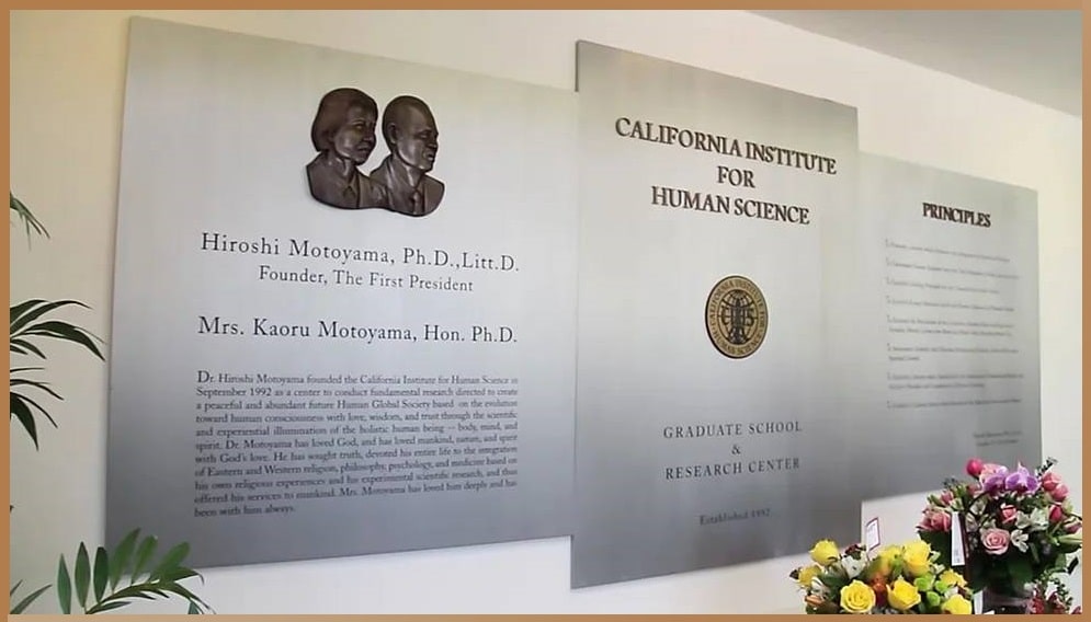 A plaque and relief at the California Institute for Human Science commemorating founder Hiroshi Motoyama and Mrs. Kaoru Motoyama, with details of Dr. Motoyama's contributions to the study of spirituality and science.