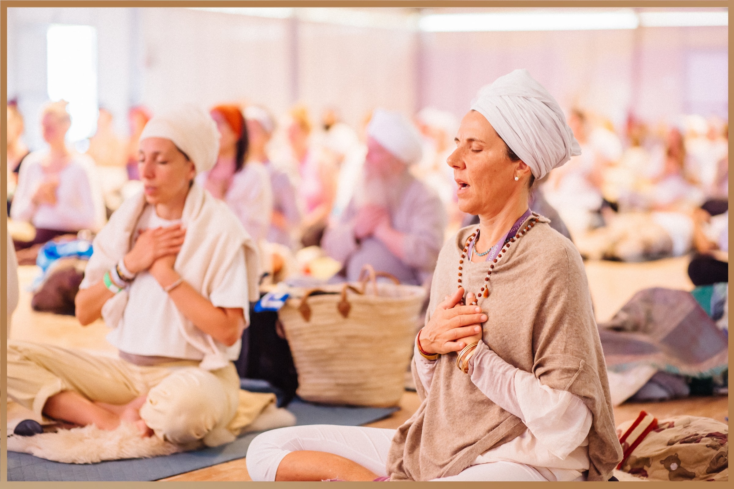 Participants in a meditative Kundalini yoga session at the European Yoga Festival in France, wearing traditional white clothing to enhance spiritual and mental focus.