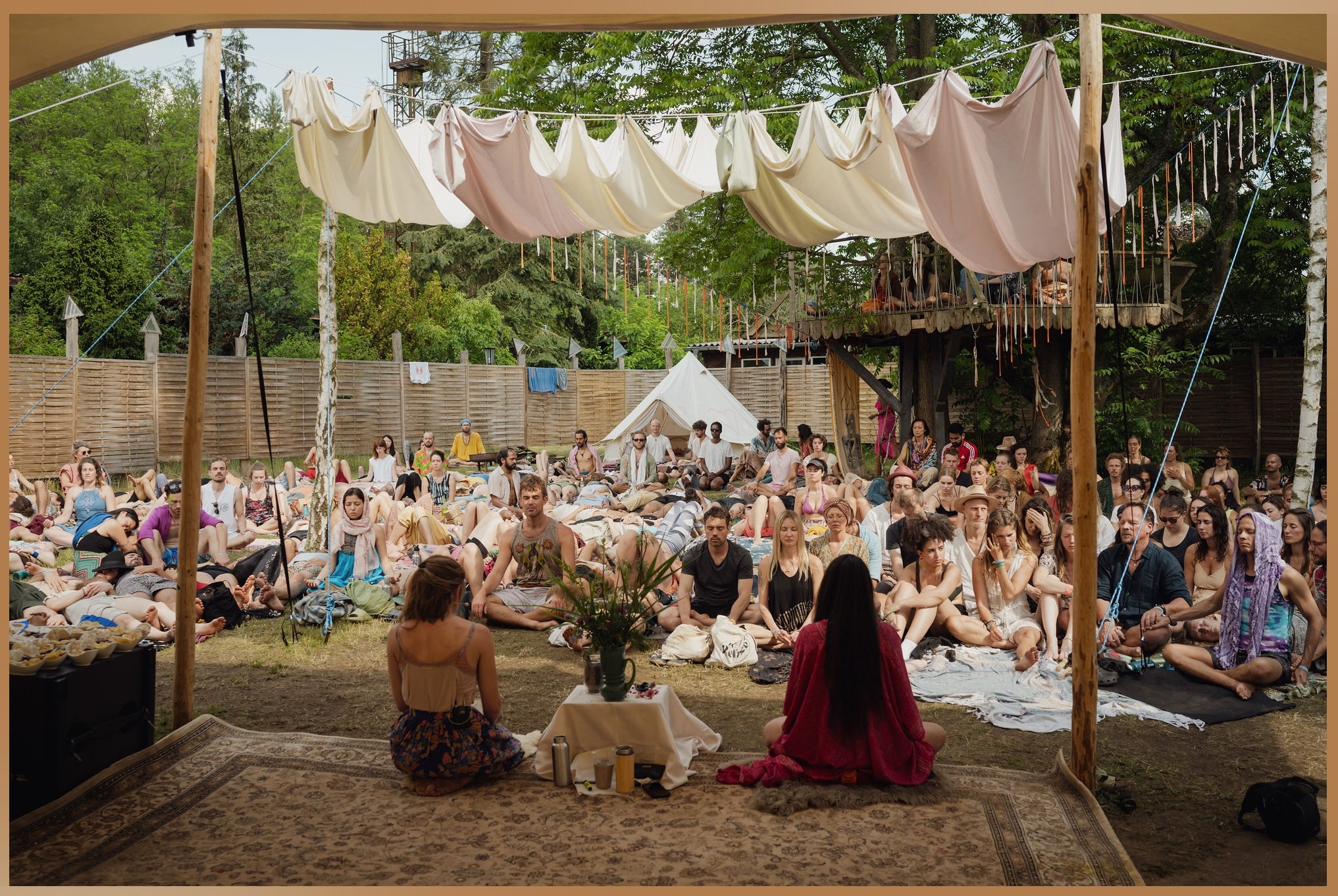 Attendees at the Pura Vida Festival Retreat in Germany, sitting outdoors during a workshop focused on holistic wellness and community building.