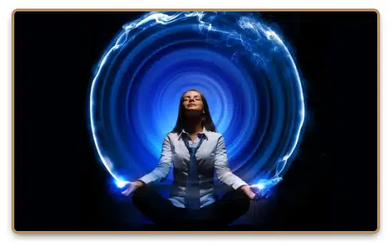 A woman meditating with dynamic blue aura energy swirling around her, symbolizing spiritual energy and meditation practices.
